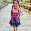 Little girl standing on bridge in colorful cotton overalls