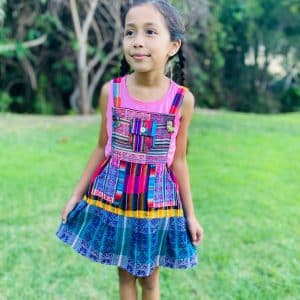 Little girl wearing colorful woven cotton jumper with patchwork pocket