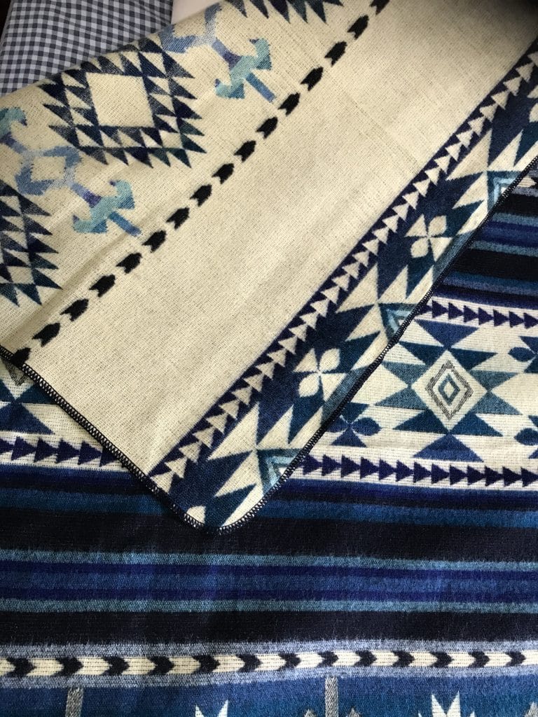 Blue & White Southwestern pattern throw folded to reveal cream reverse side