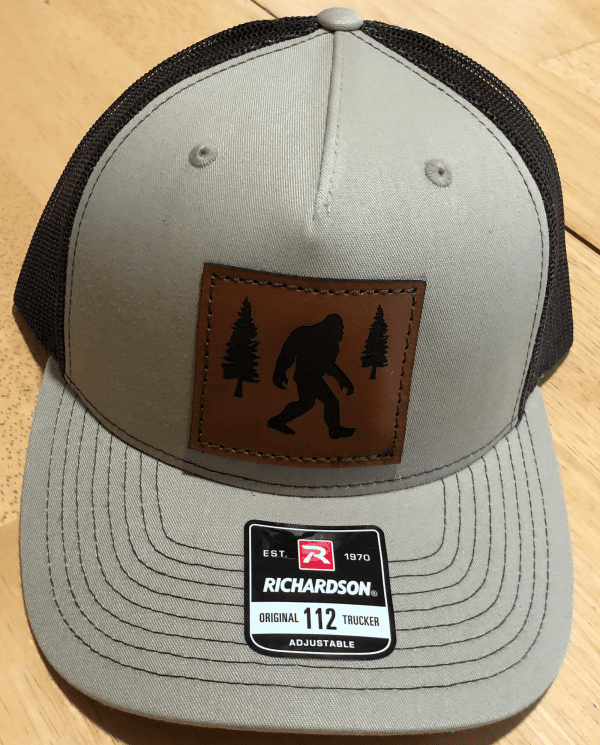 Bigfoot and trees on leather patch on khaki Richardson Trucker Hat