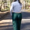 Back view of model wearing dark green harem pants with elastic waist