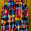 Rainbow striped cotton/poly overalls on a hanger