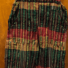 Colorful overalls in red, green, and gold stripes, on a hanger