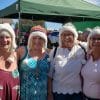 4 older ladies wearing handknit wool beanies with pompoms and earflaps