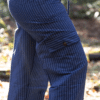 Side view of model wearing navy pants with white pinstripes