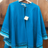 Tropical Blue Gabytex Capelet with button at neckline, shoulder button not fastened, hanging on a wooden fence