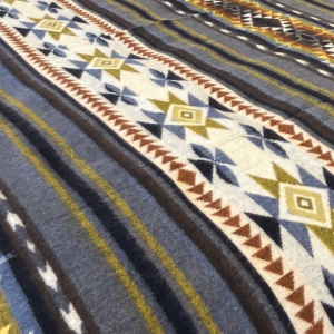 Closeup view of Gray, Brown, Mustard Yellow and Blue Southwestern design couch throw