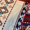 Red and Turquoise Southwestern design blanket folded back to show cream background and pattern on reverse