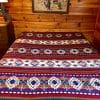 Red and Turquoise Southwestern blanket on bed in rustic bedroom
