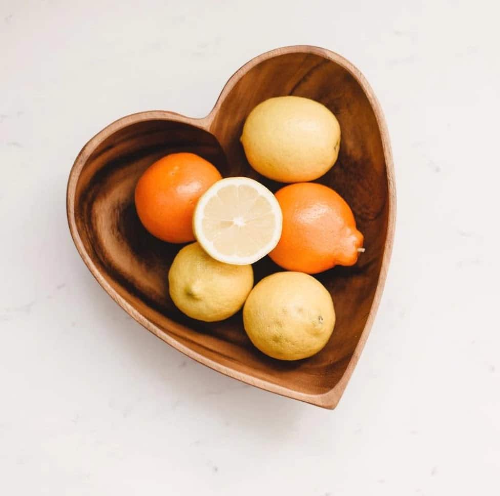 Handcarved heart-shaped acacia wood bowl with citrus fruits, part of Los Andes Shop Friendsgiving Gift Guide