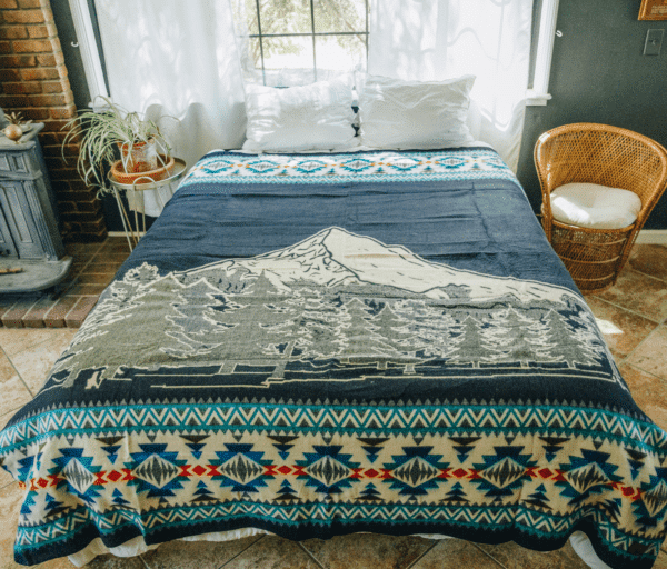 Mountain image on blue blanket with geometric border