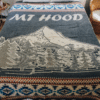 Medium Gray blanket with image of Mountain and text "Mt Hood" with geometric border, displayed on a bed
