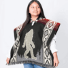 Girl model wearing poncho with Bigfoot image and geometric patterns down each side, in military green and cream with red accents