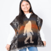 Girl wearing Bigfoot poncho in rust and brown with geometric pattern down sides