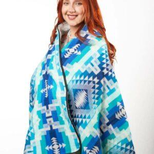 Redheaded smiling female model wearing blue and turquoise zip blanket poncho