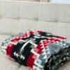 Red and black blanket poncho folded on couch