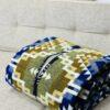 Blue and gold blanket poncho folded on couch