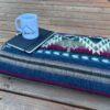 Jewel Tone Western Blanket folded on deck with journal and coffee cup