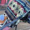 Jewel Tone Blanket with Southwestern design across back of deck chair, with journal and coffee cup.