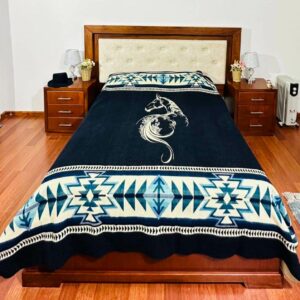 Blue blanket on bed with cream image of elegant horse and geometric pattern on top and bottom border.