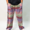 Male model wearing woven cotton pants in purple orange and green